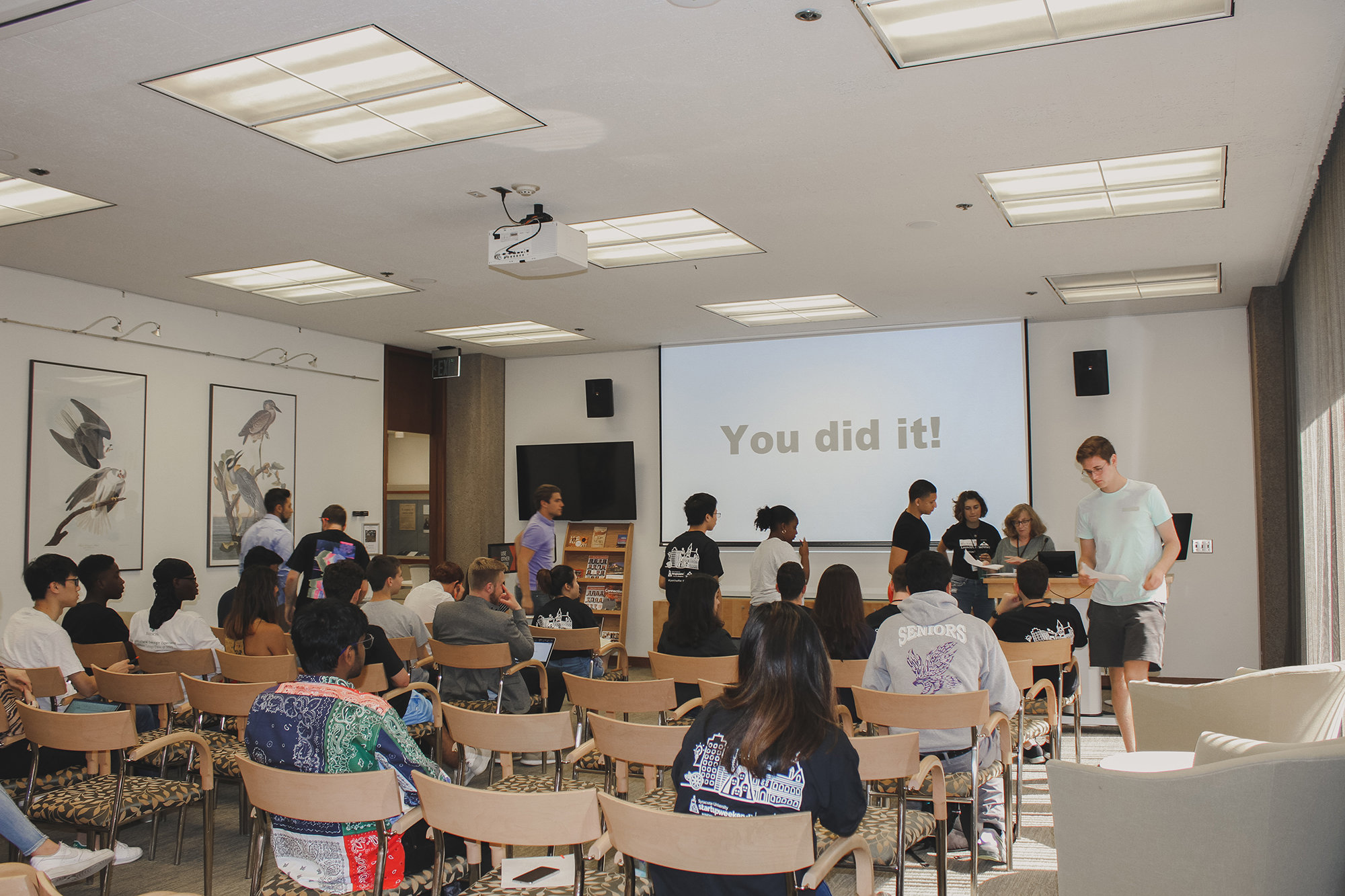 Students at the end of Startup Weekend with a slide that reads "You Did It!"