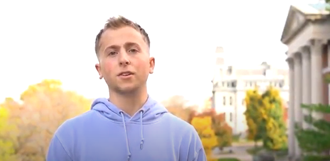 young man in a blue sweatshirt outdoors