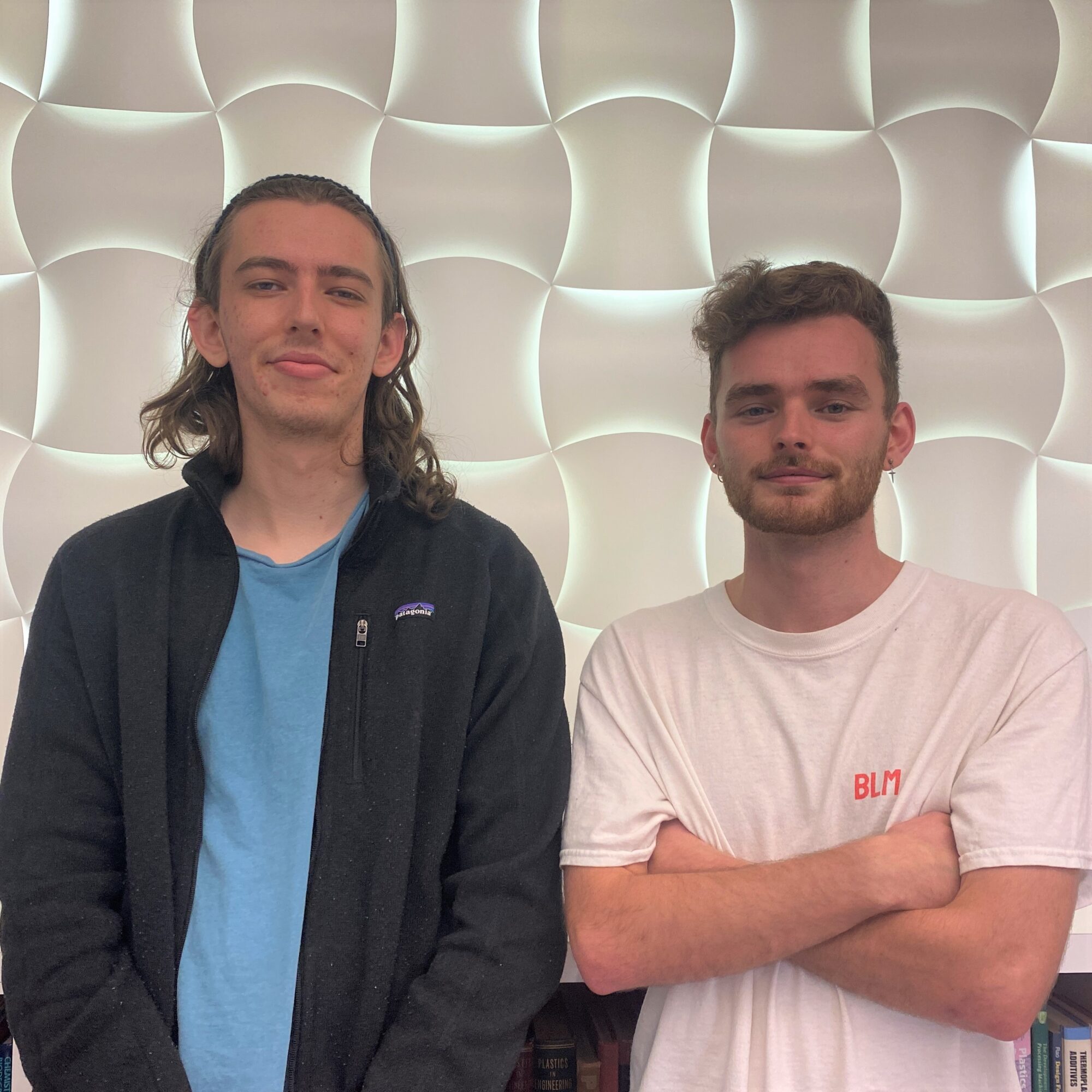 two student founders in front of a light wall