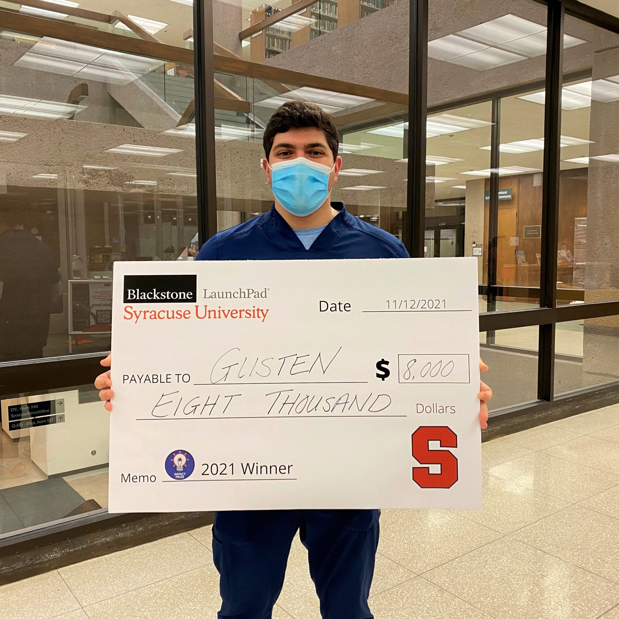 student holding a prize check